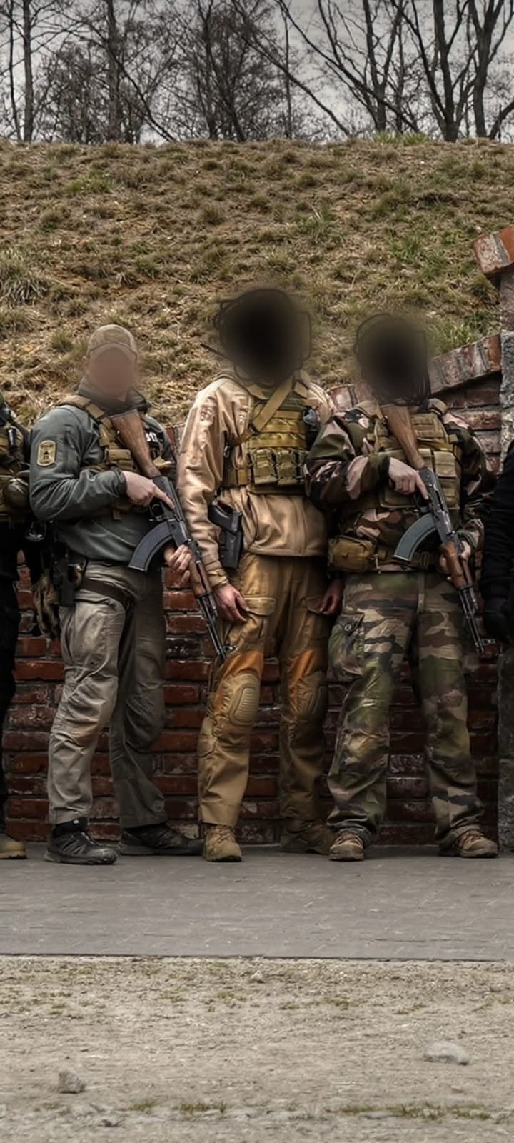 A team standing ready against a wall, faces obscured