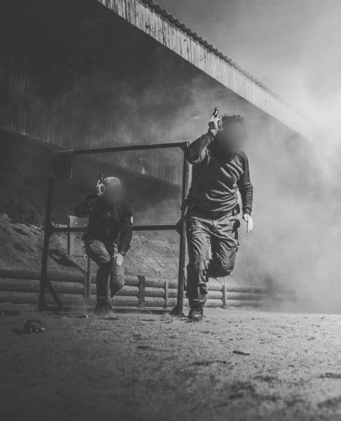 Two operators moving through smoke on a training range